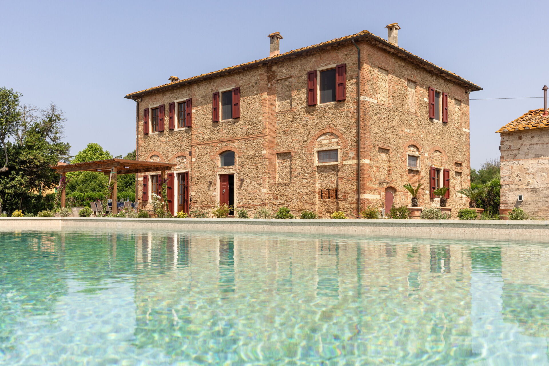 The villa pool and gardens with view across the Tuscan hills